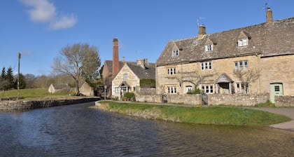 Period cottage in idyllic riverside location in prime Cotswolds village
