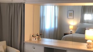A bedroom with a bed, bedside table, lamp, and a dresser with drawers. - Blue Steel Lustron - Rare - Near Starved Rock Country (Grand Ridge)