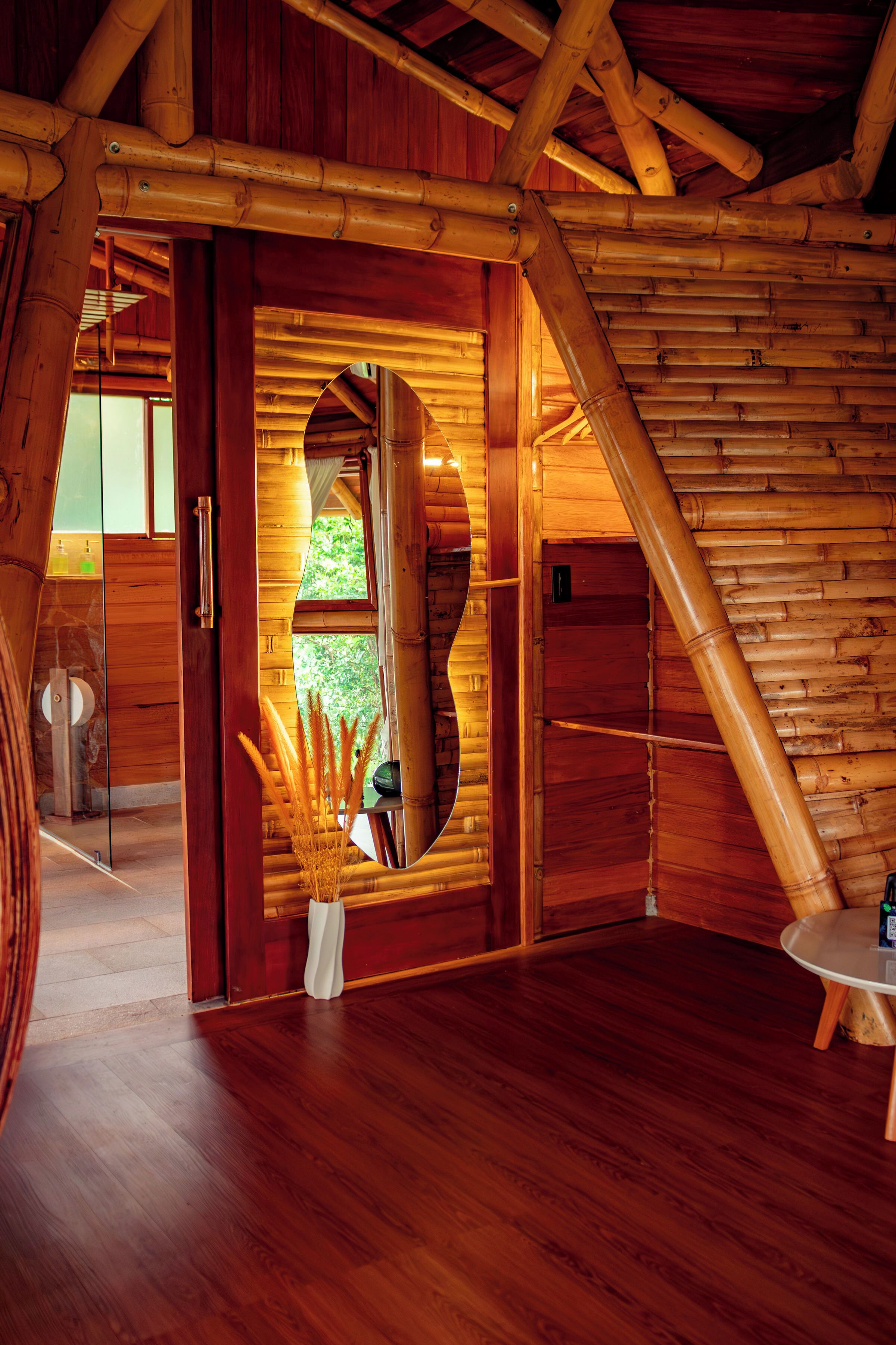 Un intérieur en bois avec un grand miroir, un plancher en bois et une petite table.