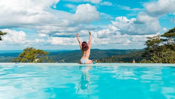 Una piscina al aire libre, sillones reclinables de piscina