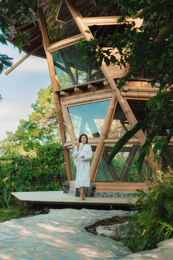 A wooden structure with a glass enclosure, surrounded by lush greenery. - Heimatlos Rainforest Lodge (Canelos)