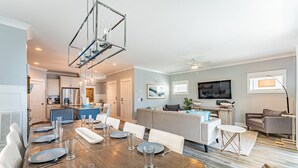 A modern living space with a dining area, kitchen, and seating area.