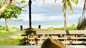 A beach view with a wooden deck and a coconut shell. - Malakati Homestay (Nacula Island)