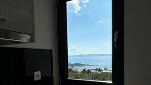 A kitchen with a window overlooking a coastal view. - Luxury villa Glory Palm in Makarska, private pool (Makarska)