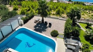 A swimming pool with a view of the sea and greenery. - Luxury villa Glory Palm in Makarska, private pool (Makarska)
