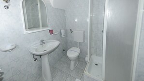 Kylpyhuone, jossa on pesuallas, wc ja suihku.