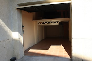 Un espacio estrecho y cerrado con suelo de baldosas y un marco de puerta blanco.