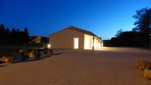 A large, open building with a flat roof and a single door, surrounded by a gravel area. - Lodging 4 Gîte RE CLIMATISE IN THE CALM OF THE GREAT VERSENNES  (Saintes)
