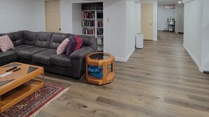 A modern living room with a grey sofa, a wooden coffee table, and a bookshelf. - Updated clean 5br house, 2(1/2) bath close to Notre Dame. (South Bend)