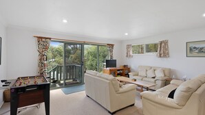 A living room with a foosball table, a sofa, a coffee table, and a television. - Glyndon Family Getaway the perfect family retreat. (VENTNOR)