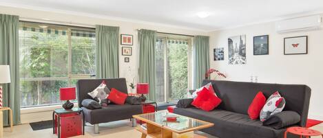 A modern living room with two sofas, a coffee table, and a side table.
