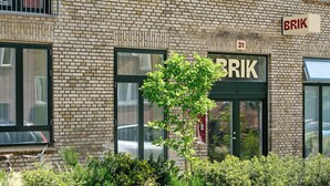 Un edifici de maó amb un cartell que diu "BRIK" i el número "31" a la part superior de l'entrada.