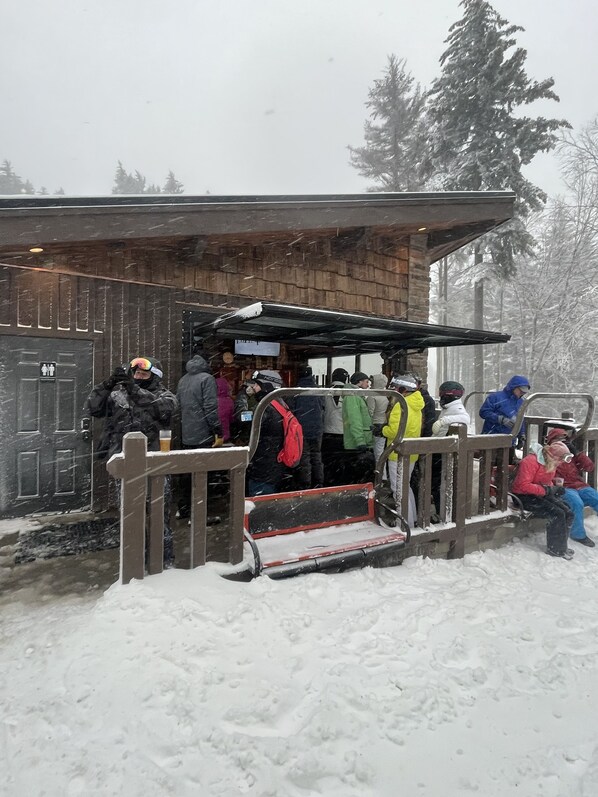 Un bâtiment en bois doté d’une entrée couverte et d’une rampe métallique menant à l’entrée.