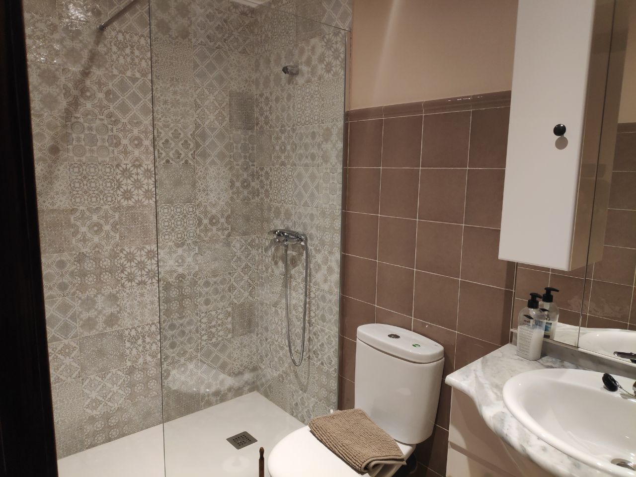 A bathroom with a shower, toilet, and sink.