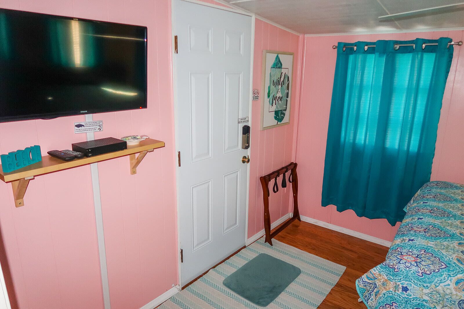 Second Bedroom - Queen Bed. Door leads to back of house and outdoor shower.