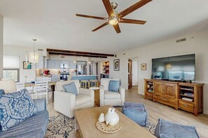 A spacious living room with a ceiling fan, a TV, and a wooden cabinet.