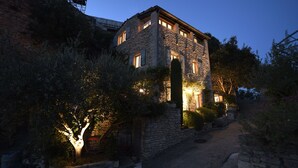 A stone building with multiple windows and a stone pathway leading to it. - Welcome to La Maison du Bonheur (Gordes)