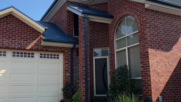 A residential building with a garage, a brick facade, and a large arched window. - Jewel on Jenner in Cowes (COWES)