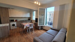 A compact living space with a kitchenette, a dining area with a table and chairs, a sofa, and a window with a view of a building. - BEST VIEW AND SUNNY Cà DEL SOL IT027042C2W4RXWZRV (Venezia)