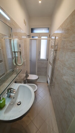 Regadera, secadora de cabello, bidet, toallas