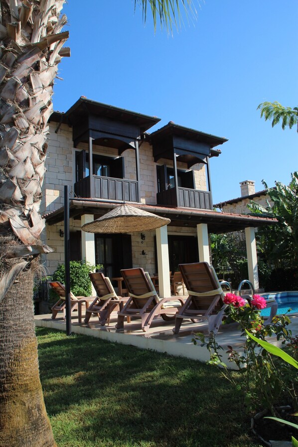 A two-story house with a balcony, a pool, and outdoor seating. - Stone Built Villa With Private Pool, Gardens And Mountain Views (Dalyan)