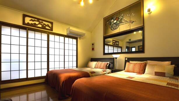 A hotel room with two beds, a large window with a view, a ceiling fan, and a wall-mounted air conditioner.