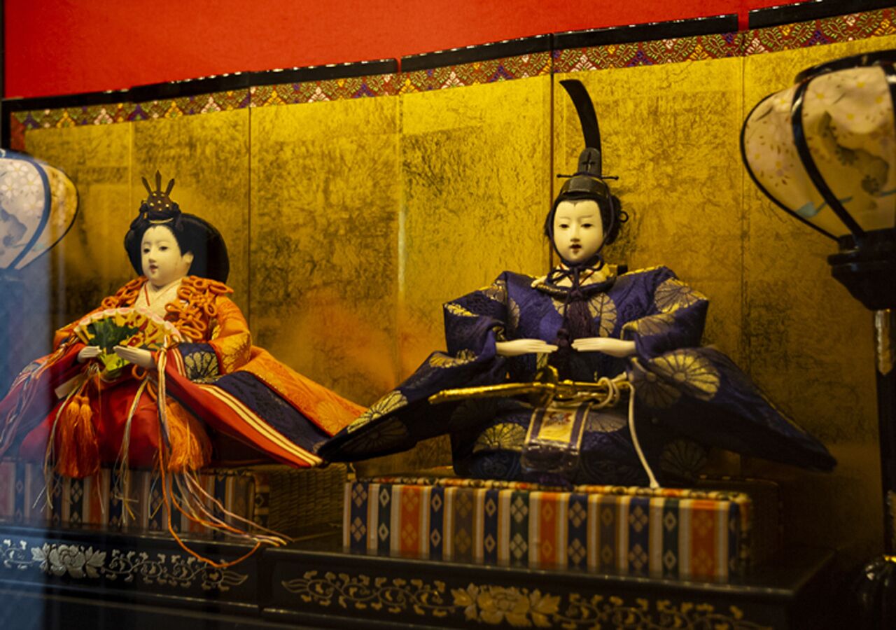 Two traditional Japanese dolls in a display case.