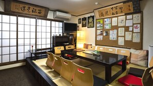 A traditional Japanese room with tatami mats, a low table, and cushions.