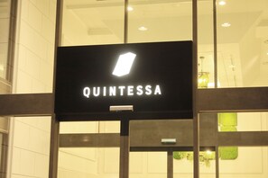 Un letrero con el nombre 'QUINTESSA' en la fachada de un edificio.