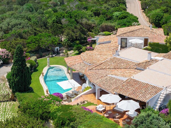 A villa with a swimming pool, outdoor seating, and a garden. - Spectacular panoramic villa in Porto Cervo center (Porto Cervo)