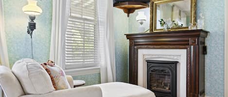 A living room with a fireplace, a television mounted above it, and a sofa with decorative pillows.
