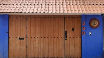 A large wooden door with a number '220' on the right side, a metal handle, and a keyhole.