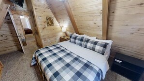 Ein Schlafzimmer mit Bett, Nachttisch, Lampe und Holzboden.