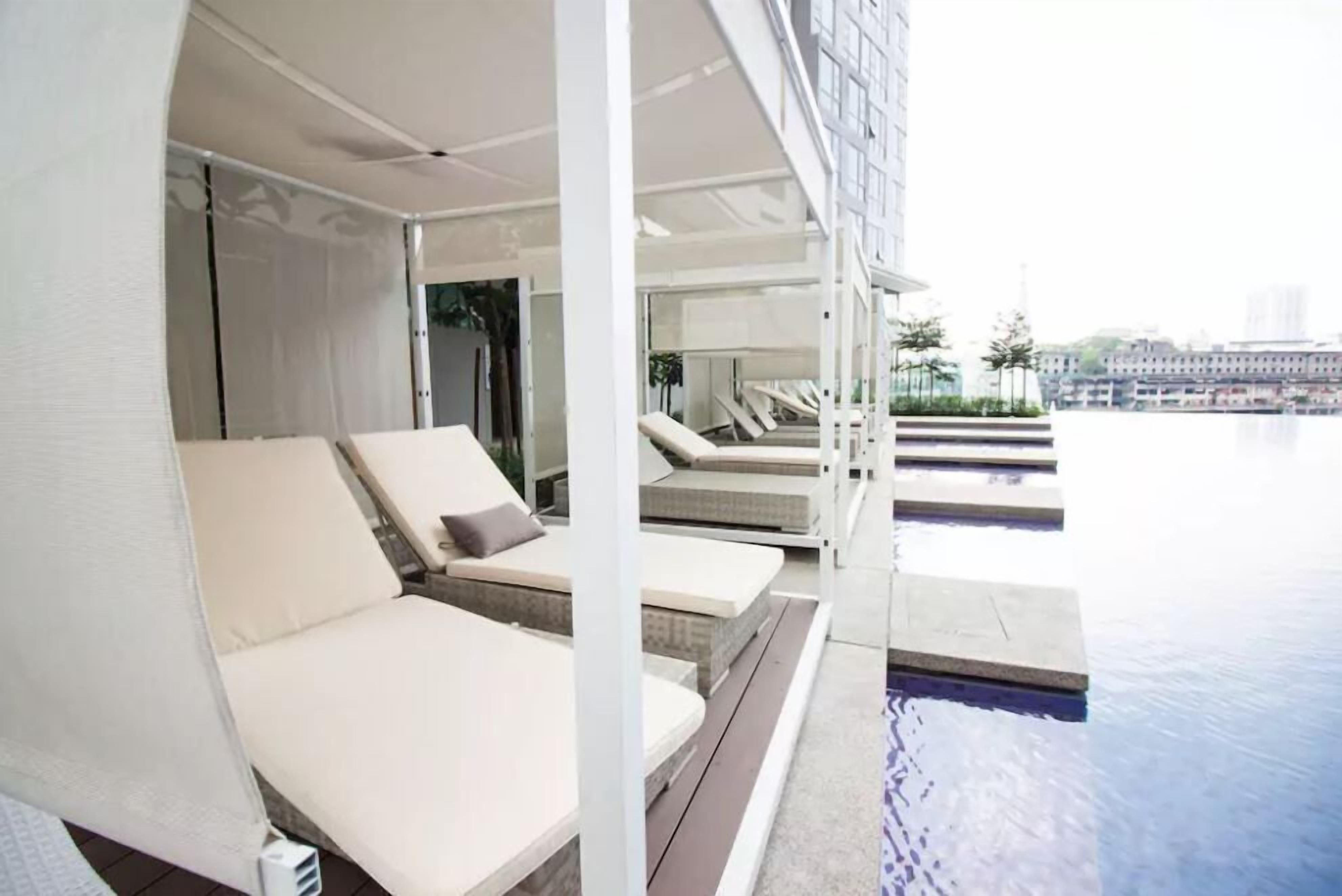 Zona de piscina en la azotea con sillones reclinables y vista panorámica de la ciudad.