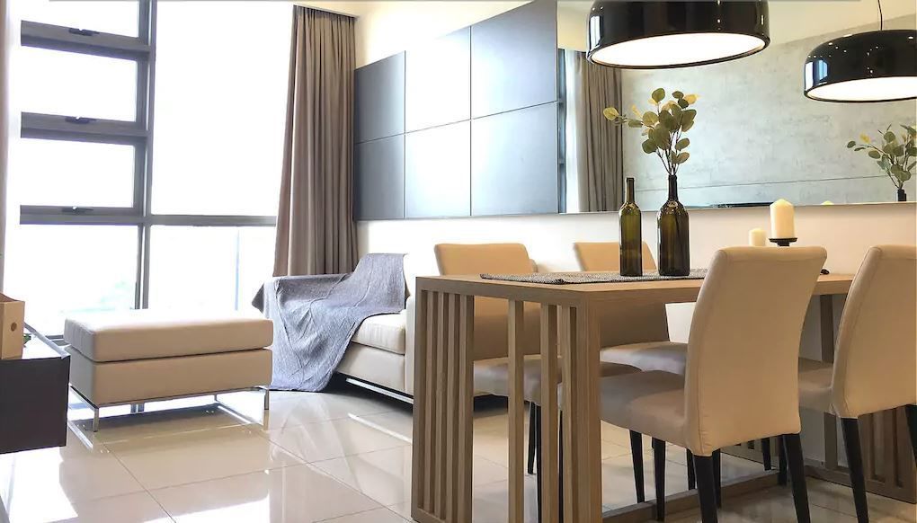 Ein modernes Hotelzimmer mit Essbereich, inklusive Holztisch, Stühlen, einer Couch und einem großen Fenster mit Vorhängen.