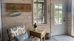 A cabin interior with wooden walls, a door with a 'Boat Rides' sign, a 'Good day' sign, and a 'On Lake Time' sign.