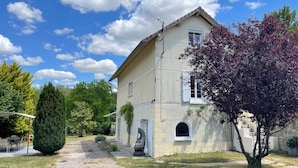 A two-story building with a beige facade, white shutters, and a small arched window. - Spacious Waterfront House with Jacuzzi for Families and Friends (Nargis)