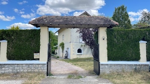 A gated entrance with a wooden archway leading to a building with a beige facade and a small arched window. - Spacious Waterfront House with Jacuzzi for Families and Friends (Nargis)