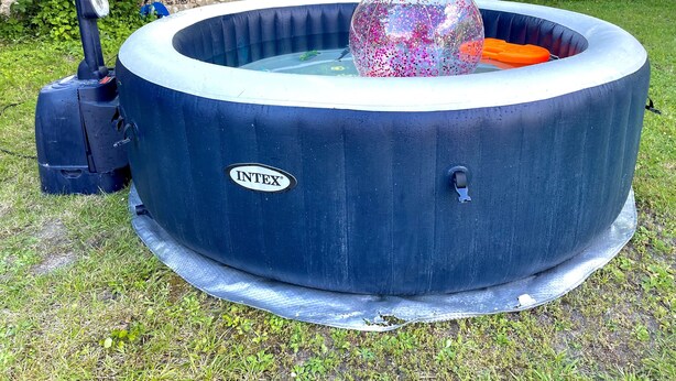 A blue inflatable hot tub with a visible brand logo, a pump, and a clear water container with colorful beads. - Spacious Waterfront House with Jacuzzi for Families and Friends (Nargis)