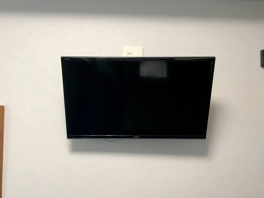 A flat-screen TV mounted on a white wall.