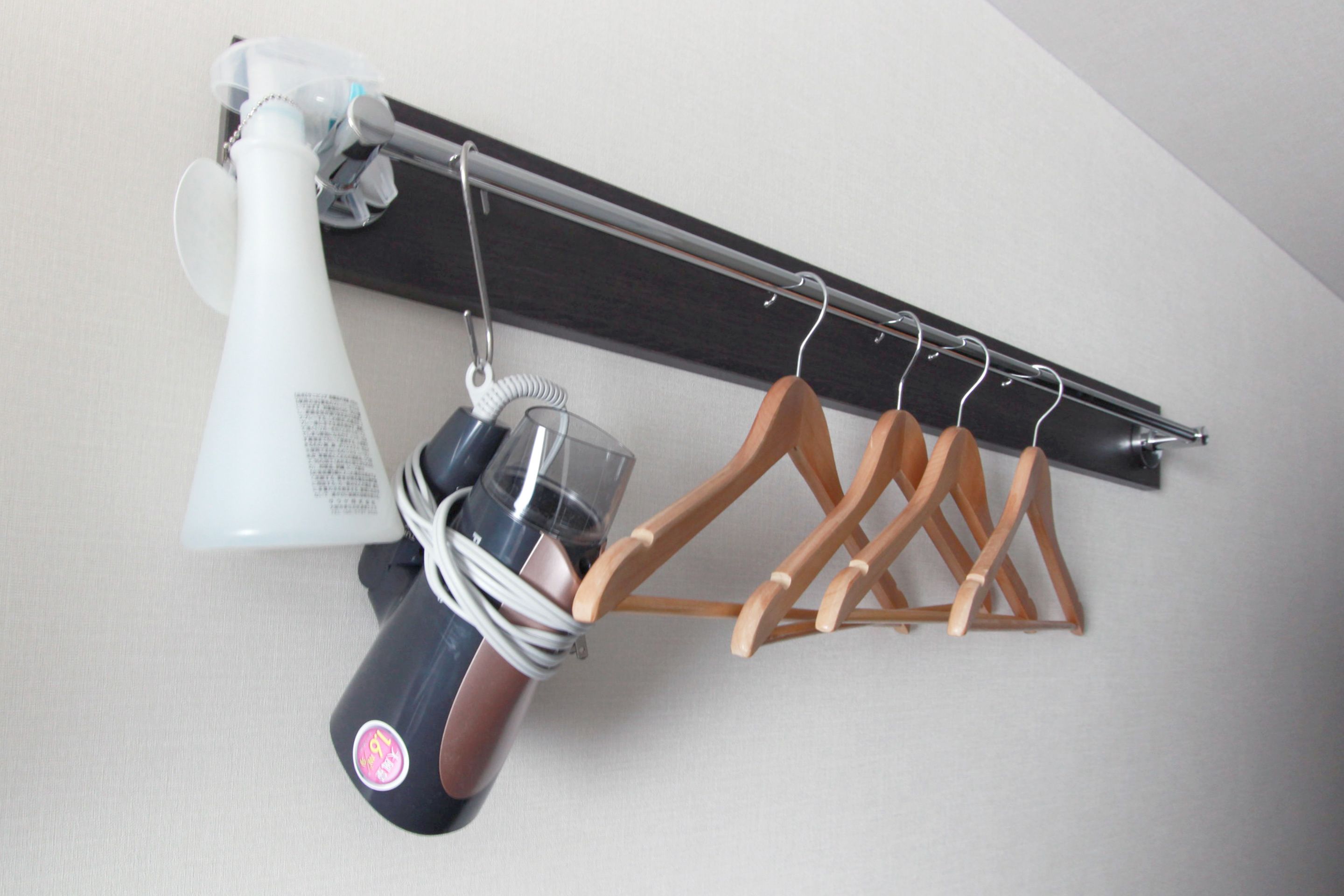 A ceiling-mounted drying rack with wooden hangers and a vacuum cleaner.