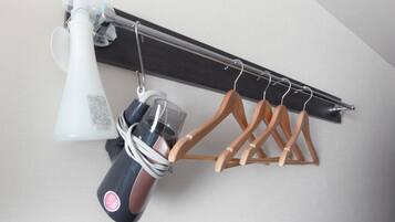 A ceiling-mounted drying rack with wooden hangers and a vacuum cleaner.