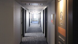 A hotel hallway with a carpeted floor, doors on both sides, and a sign indicating the 6th floor. - Hotel Trend Okazaki-Eki Mae (Okazaki)