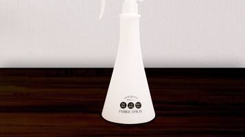 Un pulverizador de tela blanco con la etiqueta "sanipure" y "SPRAY PARA TELA" sobre una superficie de madera.