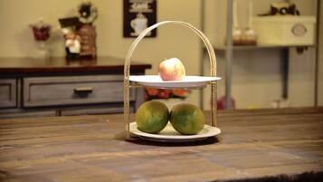 A fruit stand with a pear and two green apples on a wooden table.