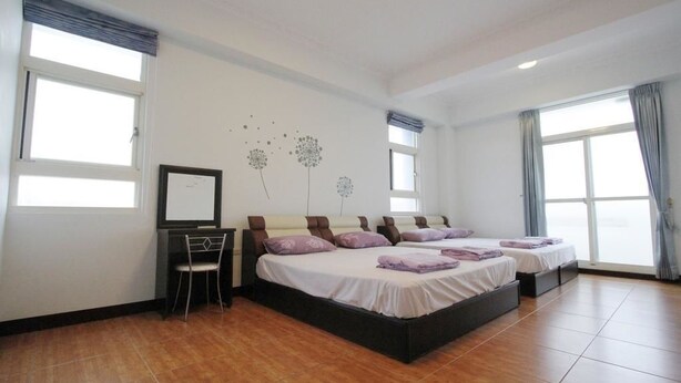 Habitación de hotel con dos camas, un escritorio y una silla.