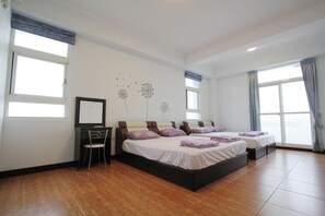 A hotel room with two beds, a desk, and a chair. - Equuleus Homestay (Magong)