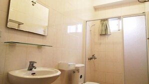 Un baño con lavamanos, inodoro y ducha.