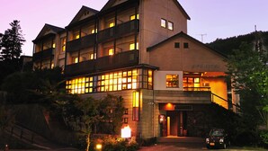 A multi-story hotel with balconies and a well-lit entrance. - Kirishima Miyama Hotel (Kirishima)