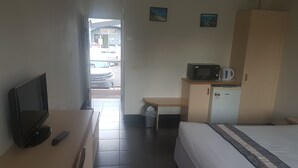 A hotel room with a bed, a desk, a television, a microwave, and a refrigerator. - Jopen Cafe & Motel (Sussex Inlet)